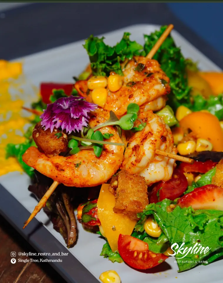 Grilled prawn skewers over a garden salad