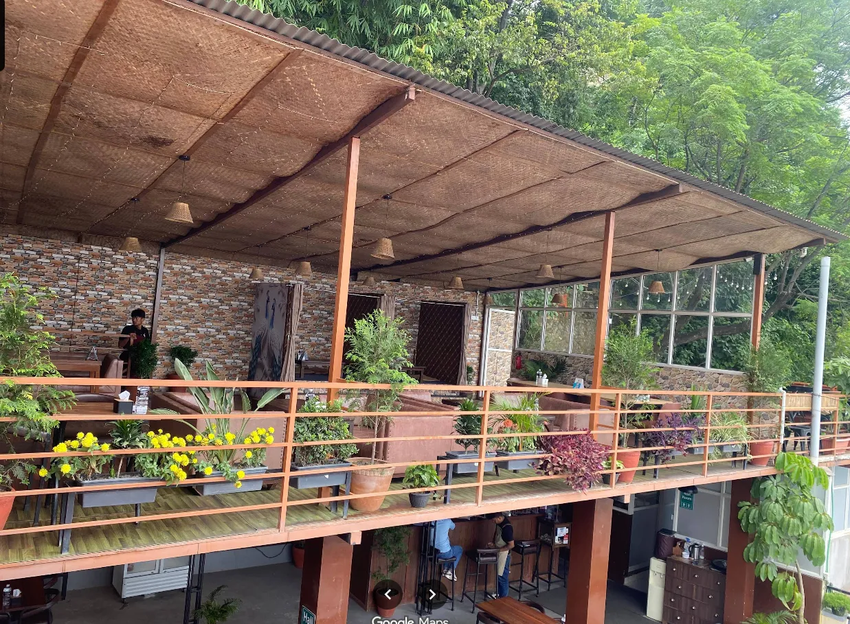 Skyline’s open terrace by day with bamboo shade and timber rails over the hillside