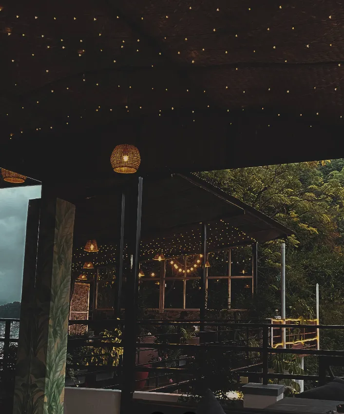 Skyline terrace glowing with string lights against the dark hillside at night